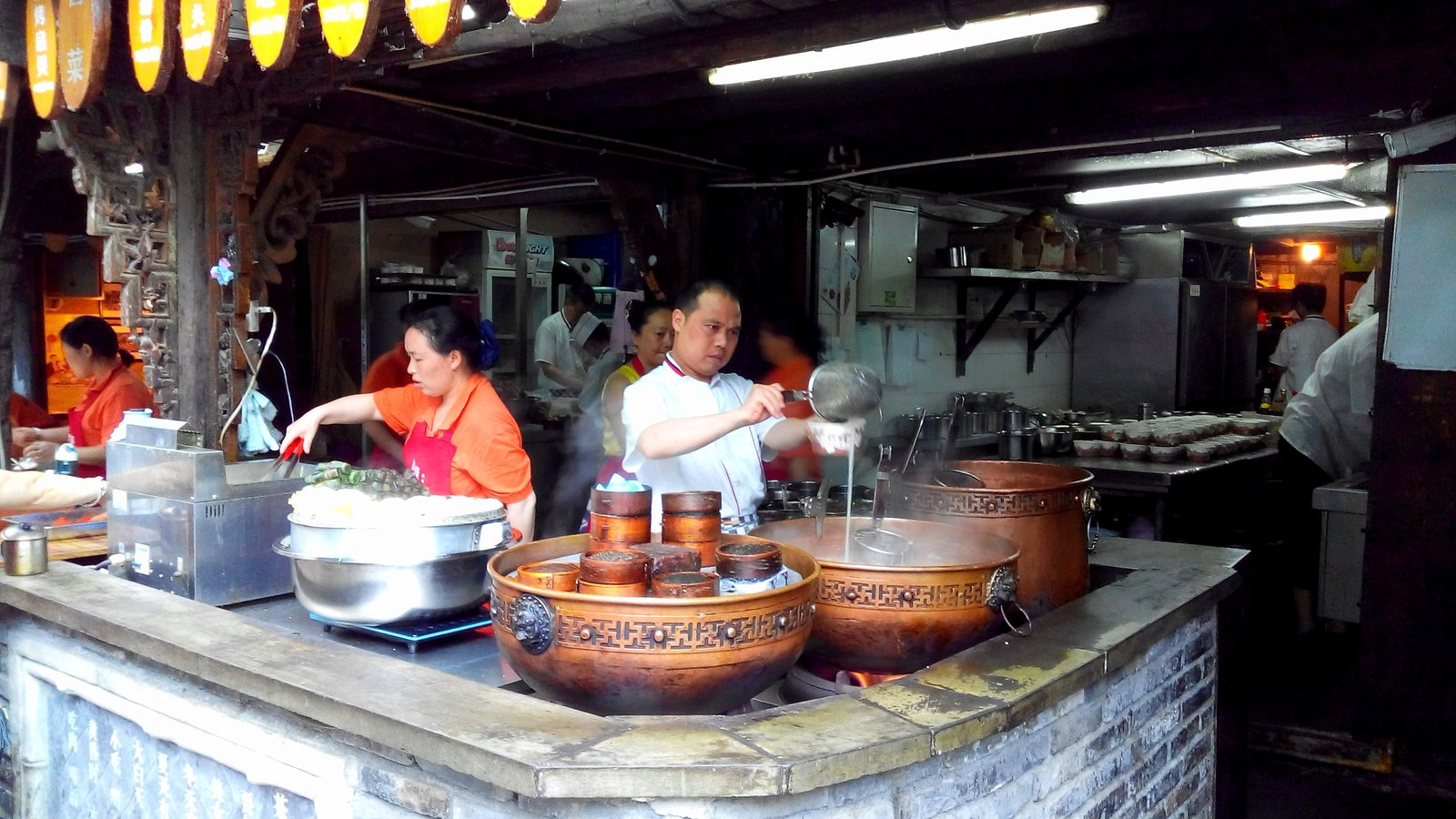 Nhân viên chế biến món ăn tại quầy trong Ngõ Rộng Ngõ Hẹp.